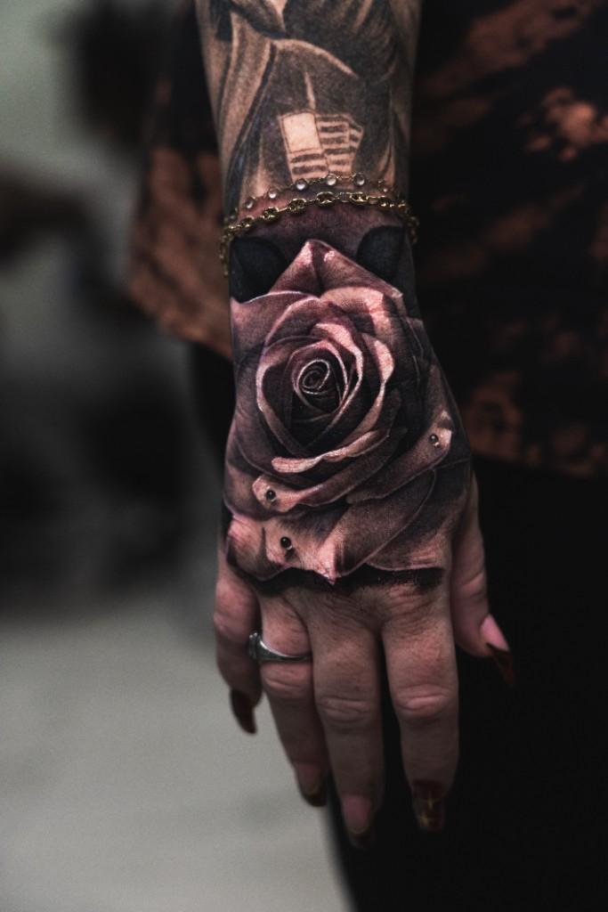 Rose on hand black and grey realism